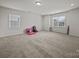 Spacious carpeted bonus room with abundant natural light, perfect for recreation and relaxation at 9582 Creighton Nw Rd, Concord, NC 28027