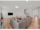 Spacious living room features hardwood floors, a staircase, and a comfortable gray sectional sofa at 9582 Creighton Nw Rd, Concord, NC 28027