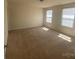 A bright bedroom features neutral carpet, window with blinds, and a ceiling light at 104 Mulligan Dr, Shelby, NC 28150