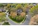 A beautiful two-story brick home sits on a manicured lawn with mature trees and a circular driveway at 10809 Wicklow Brook Ct, Charlotte, NC 28277
