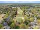 An aerial view showcasing homes bordering the manicured greens and fairways of a golf course and pond at 10809 Wicklow Brook Ct, Charlotte, NC 28277