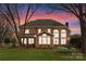 Brick home's rear view features a patio, large windows, and a spacious, well-maintained lawn at 10809 Wicklow Brook Ct, Charlotte, NC 28277