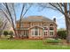 Stunning brick home exterior featuring large windows, a patio, and lush landscaping for outdoor enjoyment at 10809 Wicklow Brook Ct, Charlotte, NC 28277