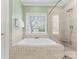 Bathroom featuring a window, soaking tub, and glass enclosed shower with bench seat at 10809 Wicklow Brook Ct, Charlotte, NC 28277