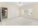 Bright bedroom with light yellow walls, neutral carpet, natural light, and en-suite bathroom access at 10809 Wicklow Brook Ct, Charlotte, NC 28277