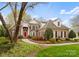 Stately brick home with a red door, black shutters, and manicured landscaping at 10809 Wicklow Brook Ct, Charlotte, NC 28277