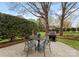 Cozy backyard patio with outdoor dining and a grill surrounded by lush landscaping and privacy hedges at 10809 Wicklow Brook Ct, Charlotte, NC 28277