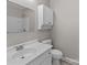 Neutral bathroom features a white vanity, mirror, and a toilet with an overhead cabinet at 1104 Crestview Dr, Salisbury, NC 28146