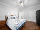 Bright bedroom with wood floors, a ceiling fan, a cozy bed, and two entry doors at 1114 Herrin Ave, Charlotte, NC 28205