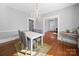 Bright dining area with hardwood floors, white table and grey chairs, chandelier, and vintage display table at 1114 Herrin Ave, Charlotte, NC 28205