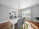 Bright dining room boasts hardwood floors, white table and grey chairs, and a decorative chandelier, window with curtains at 1114 Herrin Ave, Charlotte, NC 28205