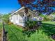 Charming white home featuring a well-manicured front yard with lush green grass and beautiful landscaping at 1114 Herrin Ave, Charlotte, NC 28205