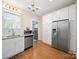 Updated kitchen features stainless steel refrigerator, white cabinets, granite countertops and hardwood flooring at 1114 Herrin Ave, Charlotte, NC 28205