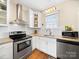 Updated kitchen features stainless steel appliances, white cabinets, granite countertops and hardwood flooring at 1114 Herrin Ave, Charlotte, NC 28205