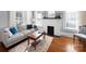 Inviting living room featuring a painted brick fireplace and hardwood floors with plentiful natural light at 1114 Herrin Ave, Charlotte, NC 28205