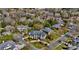 An aerial view showcases a stately home nestled within a neighborhood with mature trees and a pond at 11236 Mcclure Manor Dr, Charlotte, NC 28277