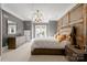 Bedroom showcasing a gray accent wall, a modern chandelier, and light-filled french doors at 11236 Mcclure Manor Dr, Charlotte, NC 28277