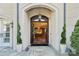 Grand entrance with stone tile, manicured spiral topiary and a glimpse of the interior at 11236 Mcclure Manor Dr, Charlotte, NC 28277