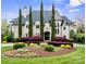 Stately home featuring a landscaped front yard, manicured bushes and tall evergreen trees at 11236 Mcclure Manor Dr, Charlotte, NC 28277