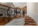 Elegant staircase with hardwood steps and decorative wrought iron railing at 11236 Mcclure Manor Dr, Charlotte, NC 28277