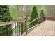 Spacious wooden deck with black metal railing overlooking a serene wooded area at 113 Duval Ct, Mooresville, NC 28117