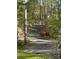 Long paved driveway leading through a lush, wooded landscape with mature trees at 113 Duval Ct, Mooresville, NC 28117