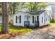 Charming home featuring a front porch, crisp white siding, and black shutters in a serene, wooded setting at 1157 Cedar Grove Ln, Rock Hill, SC 29732