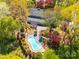 Aerial view of a home with a pool, patio, pergola, and lush landscaping surrounded by mature trees at 1206 Heatherloch Dr, Gastonia, NC 28054