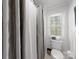 Bathroom featuring toilet, window, shower with shower curtain, and tile floor at 1206 Heatherloch Dr, Gastonia, NC 28054