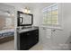 Bathroom with granite countertop, a framed mirror, and a window over the sink at 1206 Heatherloch Dr, Gastonia, NC 28054