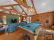 Spacious game room with wood paneling, beamed ceilings, and a classic pool table at 1206 Heatherloch Dr, Gastonia, NC 28054