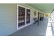 Charming porch with a metal bench and plants next to windows in a light green home at 1206 Heatherloch Dr, Gastonia, NC 28054