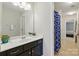 Bathroom with large mirror, white countertops, dark cabinets, and blue patterned shower curtain at 1224 Screech Owl Rd, Waxhaw, NC 28173