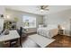 Bright bedroom with a ceiling fan, hardwood floors, desk, chair, white shelves, and large windows at 1224 Screech Owl Rd, Waxhaw, NC 28173
