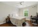 Bedroom with hardwood floors, ceiling fan, grey walls, a bed, and an office area with desk and chair at 1224 Screech Owl Rd, Waxhaw, NC 28173