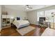 Bedroom with hardwood floors, ceiling fan, grey walls, a bed, and an office area with desk and chair at 1224 Screech Owl Rd, Waxhaw, NC 28173