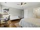 Bedroom with hardwood floors, ceiling fan, grey walls, a bed, and a desk with shelves at 1224 Screech Owl Rd, Waxhaw, NC 28173