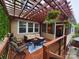 Cozy outdoor deck with pergola, furniture, overhead lights, and vibrant hanging plants at 1224 Screech Owl Rd, Waxhaw, NC 28173