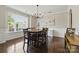 Elegant dining room with a wooden table and chairs, chandelier, and a large window at 1224 Screech Owl Rd, Waxhaw, NC 28173