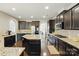 Open kitchen with dark cabinets, granite countertops, stainless steel appliances and hardwood floors at 1224 Screech Owl Rd, Waxhaw, NC 28173