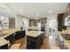 Spacious kitchen with granite countertops, dark cabinets, stainless steel appliances and a large island at 1224 Screech Owl Rd, Waxhaw, NC 28173