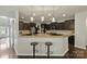 Kitchen featuring a breakfast bar, dark cabinets, granite countertops, pendant lights and stainless steel appliances at 1224 Screech Owl Rd, Waxhaw, NC 28173