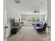A spacious living room with a sleek futon, carpeted floors, and a ceiling fan at 1224 Screech Owl Rd, Waxhaw, NC 28173