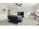 This living room features carpet flooring, a ceiling fan, and a TV at 1224 Screech Owl Rd, Waxhaw, NC 28173