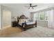 Bedroom with a ceiling fan, plush carpet, large windows, and an ensuite bathroom at 1224 Screech Owl Rd, Waxhaw, NC 28173