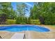 View of private backyard swimming pool surrounded by lush landscaping and a patio at 1224 Screech Owl Rd, Waxhaw, NC 28173