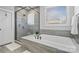 Modern bathroom featuring a glass shower, soaking tub, and gray tiled walls at 1255 Fishing Creek Rd, Clover, SC 29710