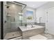 Sleek bathroom featuring a glass-enclosed shower, soaking tub and gray tile surround at 1255 Fishing Creek Rd, Clover, SC 29710