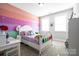 bedroom features a white wood bed frame, colorful accent wall, and modern design at 1255 Fishing Creek Rd, Clover, SC 29710