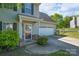 Home featuring a covered porch, driveway, an attached garage, and beautifully landscaped front yard at 12604 Cardinal Point Rd, Charlotte, NC 28269